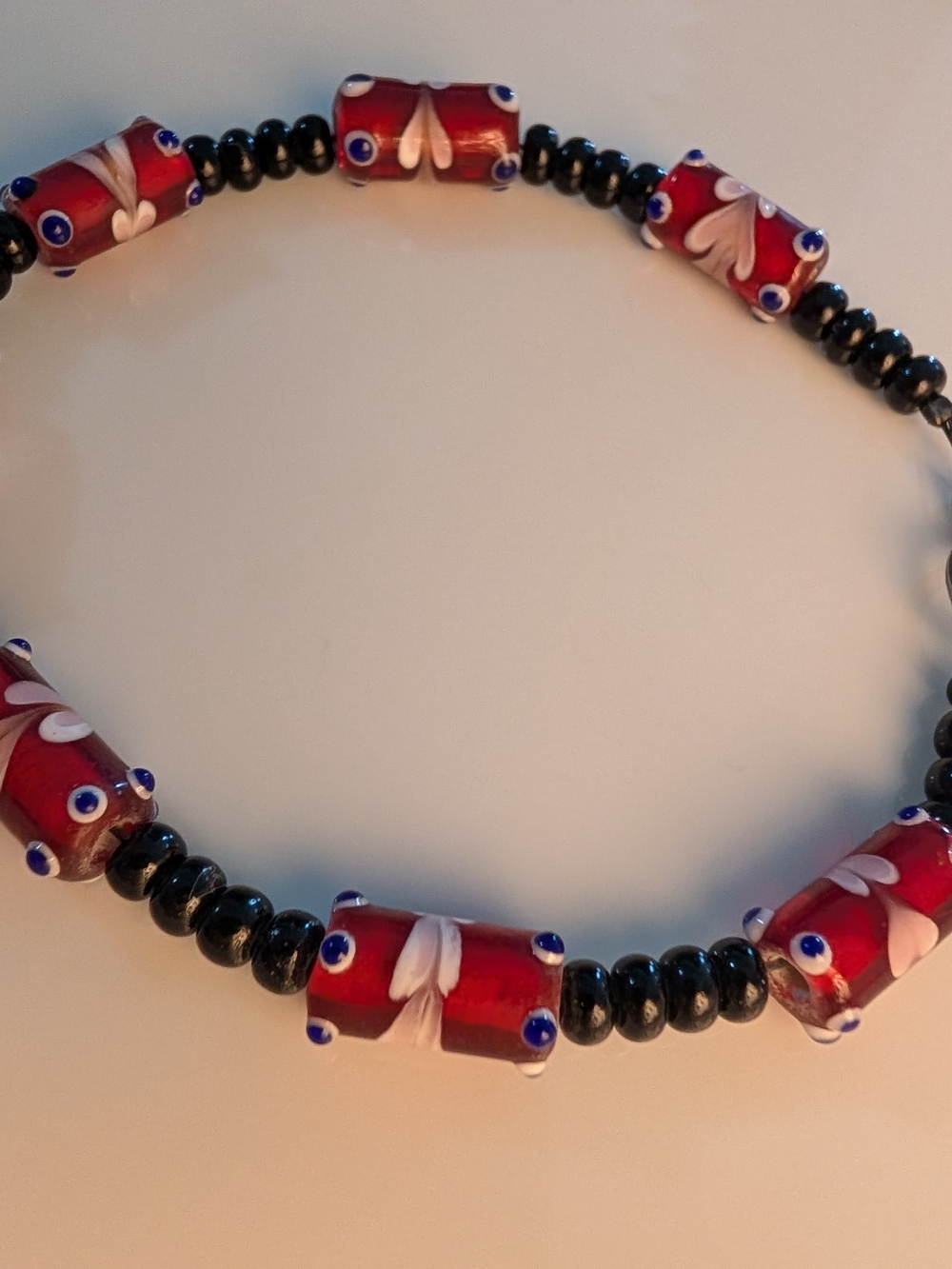 Hand Crafted Red and Black Beaded Glass Bracelet with White Floral Details